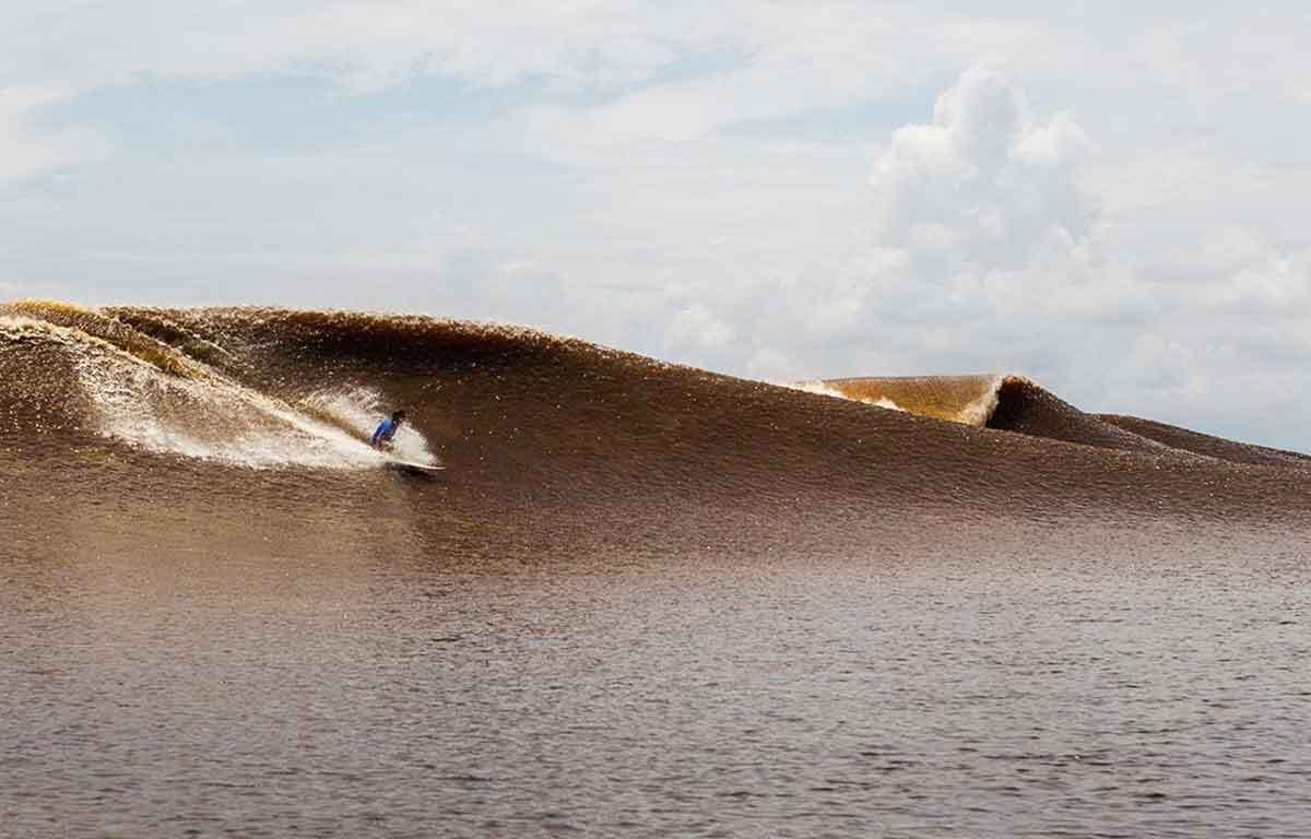 Surfing Tidal Bores||Tom Curren with mud on his hands.|